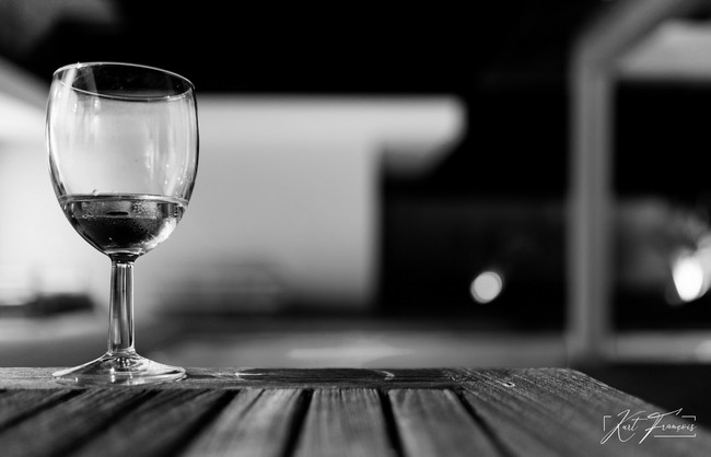 Glass of white Wine of on a table in front of blue pool at a Villa in Tamarin